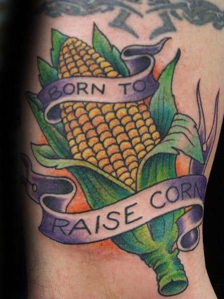 Colorful tattoo of a corn cob wrapped in a banner reading 'Born to Raise Corn,' featuring bold outlines and vibrant shading.
