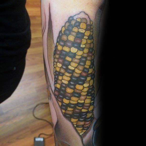 Realistic tattoo of multicolored Indian corn with detailed shading and vibrant hues, creating a bold and textured design on the skin.