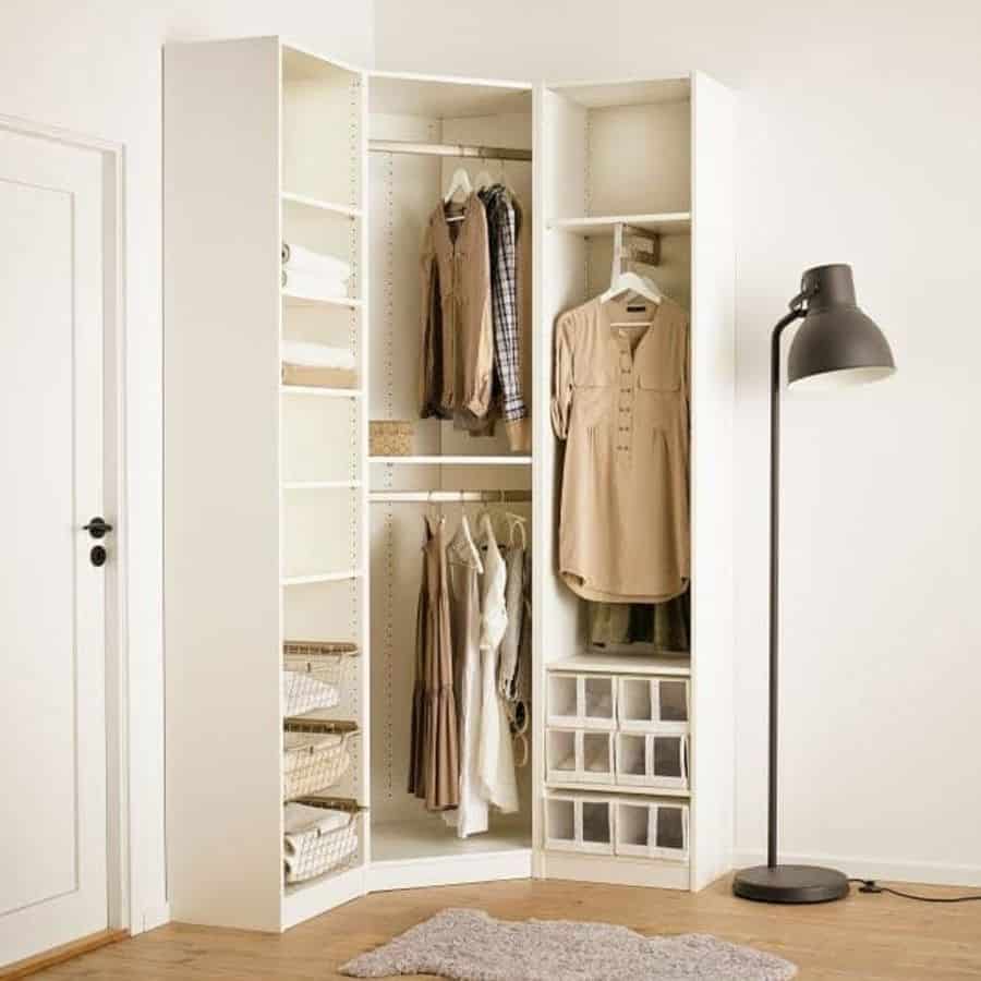 Corner bedroom closet with open shelving, hanging space, and black floor lamp.