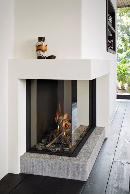 Corner gas fireplace with glass panels, sleek white surround, and stone base.