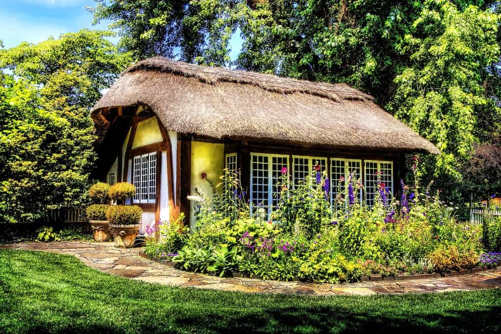 cottage hut thatch roof colorful garden stone pathway