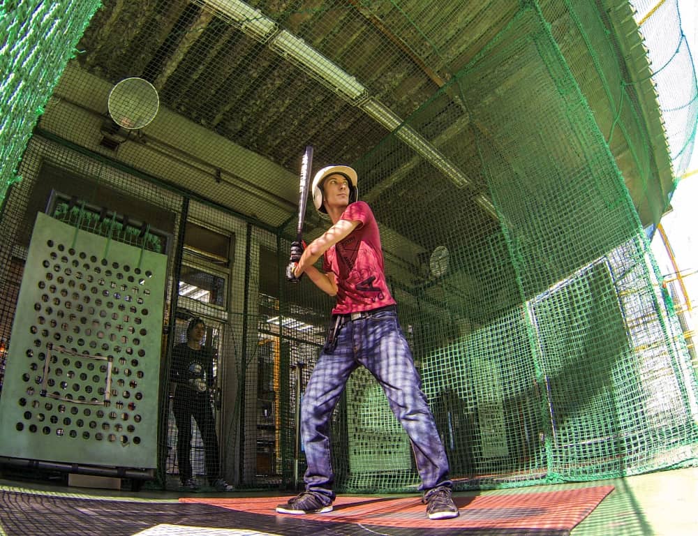 couple enjoy playing on batting cage