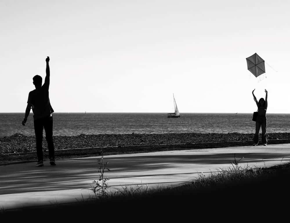 couple flying kite on windy day