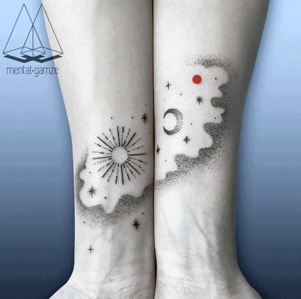 Matching ankle tattoos of cosmic designs featuring the sun, moon, stars, and a red planet, symbolizing unity across space and time.