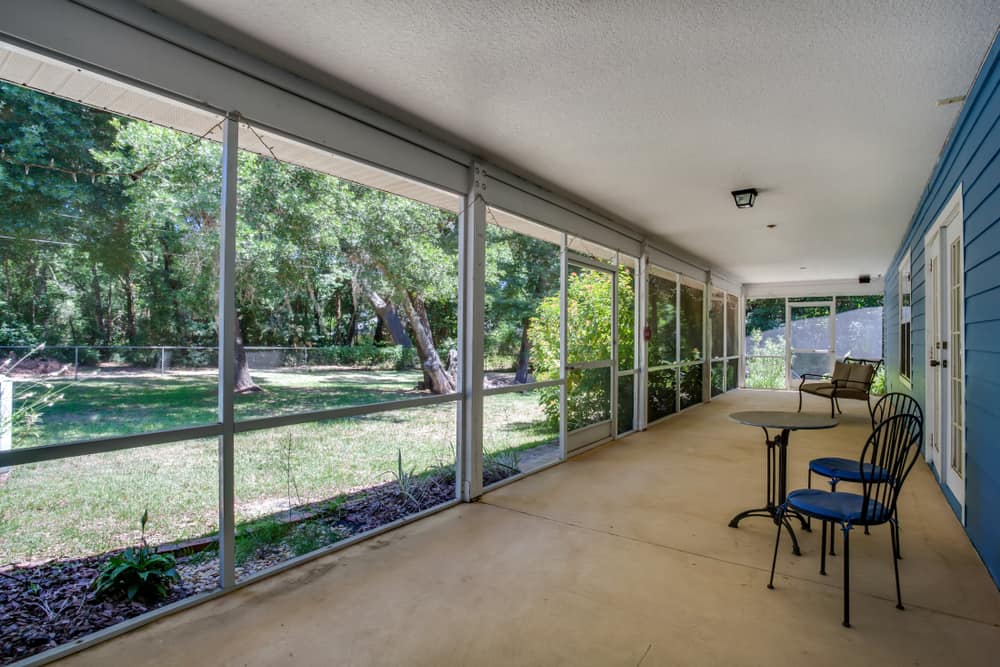 covered enclosed patio table and chairs concrete floor 