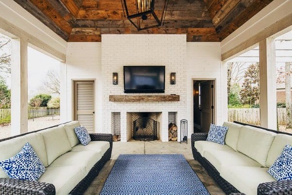 Patio featuring two sofas, a rug, fireplace, and TV under a wooden ceiling