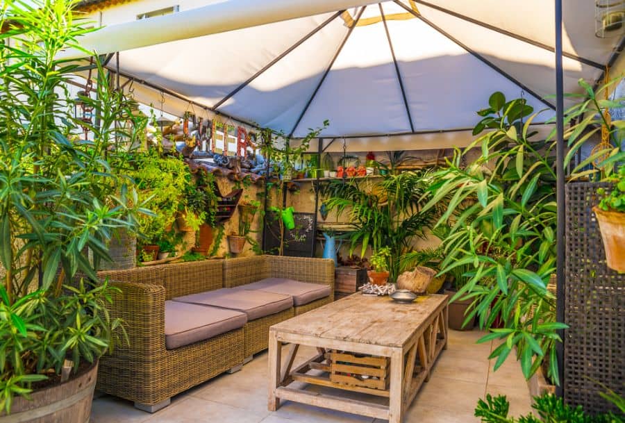 small patio with shade covering and wicker sofa