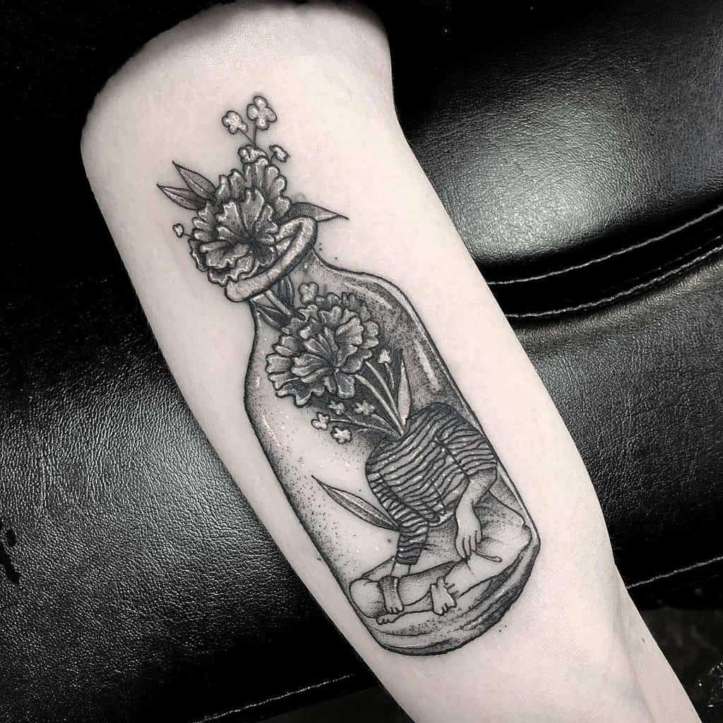 Tattoo of a person with carnation flowers  and leaves growing from their head, inside a bottle