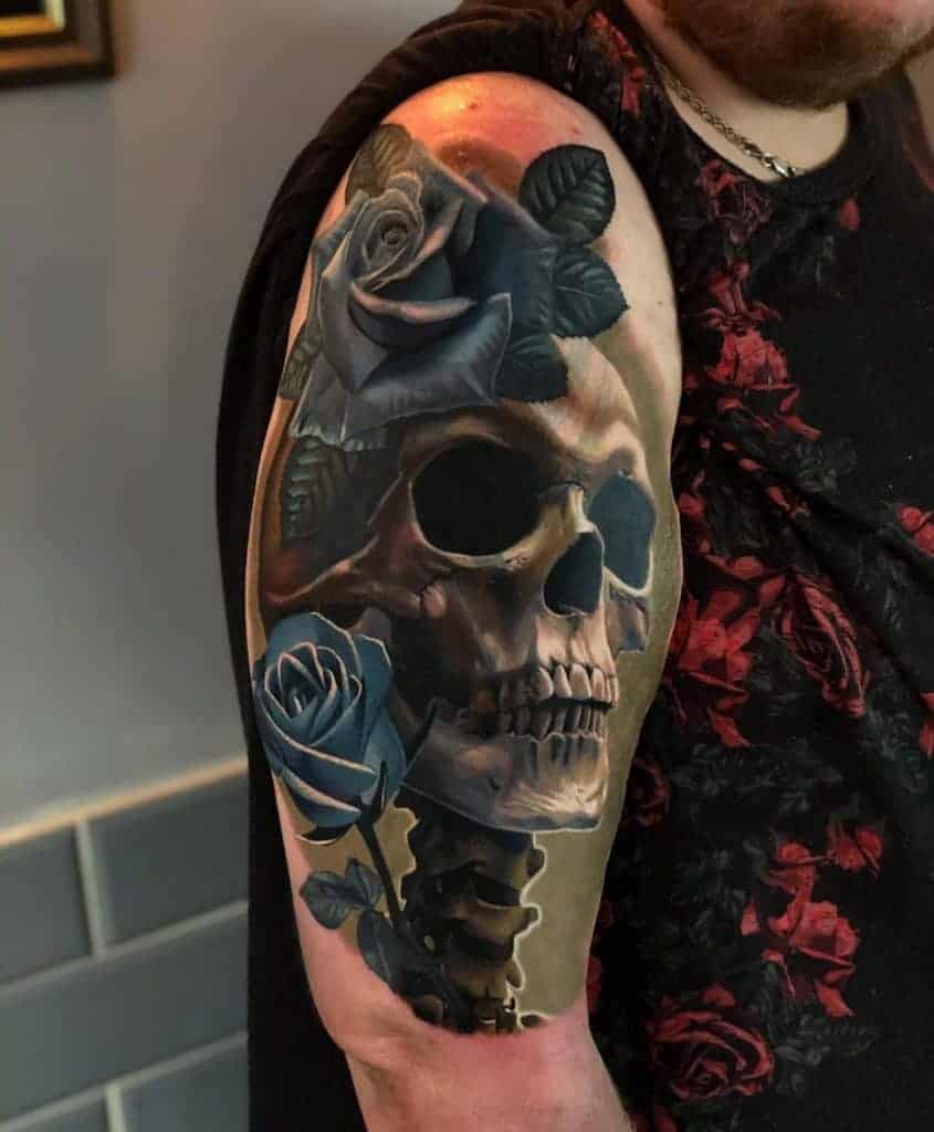 Tattoo of a skull and roses on an upper arm