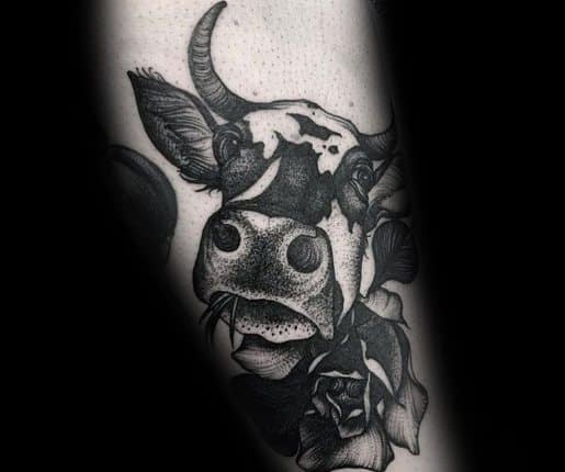 Blackwork cow tattoo with stippling technique, showcasing detailed facial features and bold floral elements around the neck.