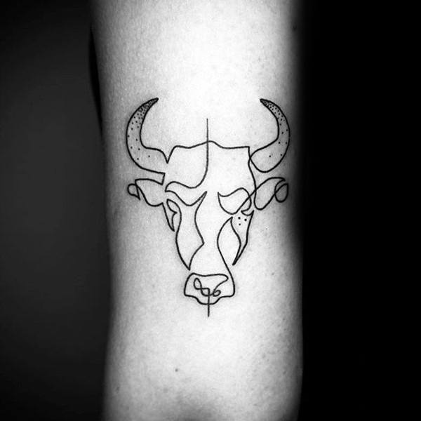 Minimal single-line cow head tattoo with bold horn outlines and abstract geometric symmetry on the inner arm.