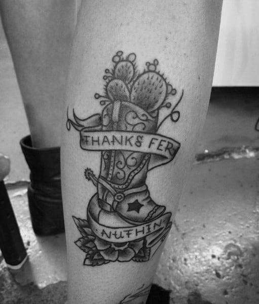 Tattoo of a cowboy boot with cacti growing from it, wrapped in a banner reading "Thanks Fer Nuthin," blending Western grit with attitude.