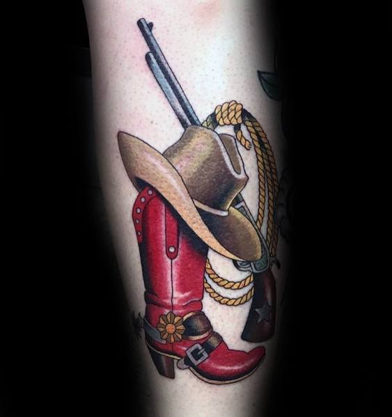 Tattoo of a red cowboy boot with a hat, rifle, and rope, symbolizing Western culture, adventure, and the spirit of the Wild West.