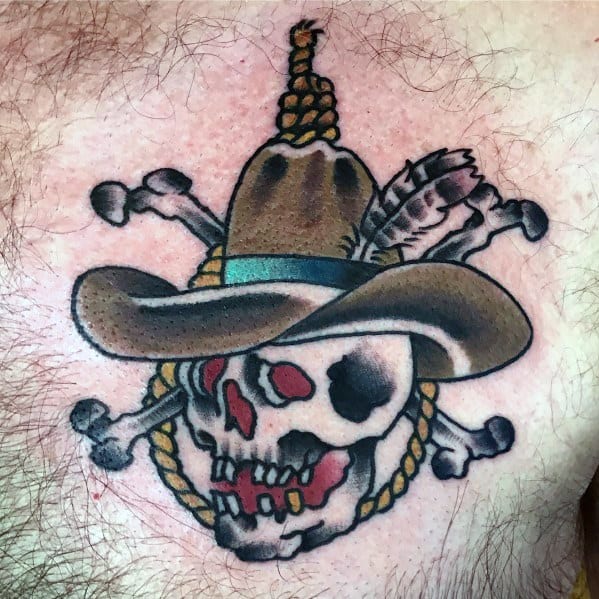 Tattoo of a cowboy skull with a noose, crossed bones, and a brown hat with a feather, done in a bold Western style with vibrant details.