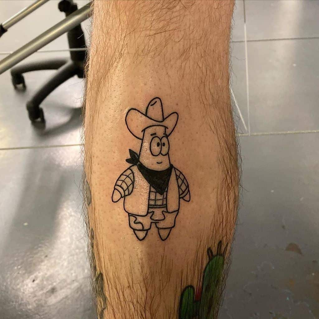 A black ink tattoo of a cartoon starfish character dressed as a cowboy, wearing a hat, vest, and bandana, placed on the lower leg.