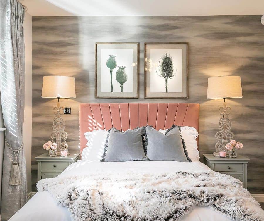 Cozy bedroom with pink headboard, soft pillows, and warm lighting from matching lamps on bedside tables