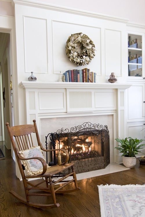 cozy white fireplace in country living room with rocking chair