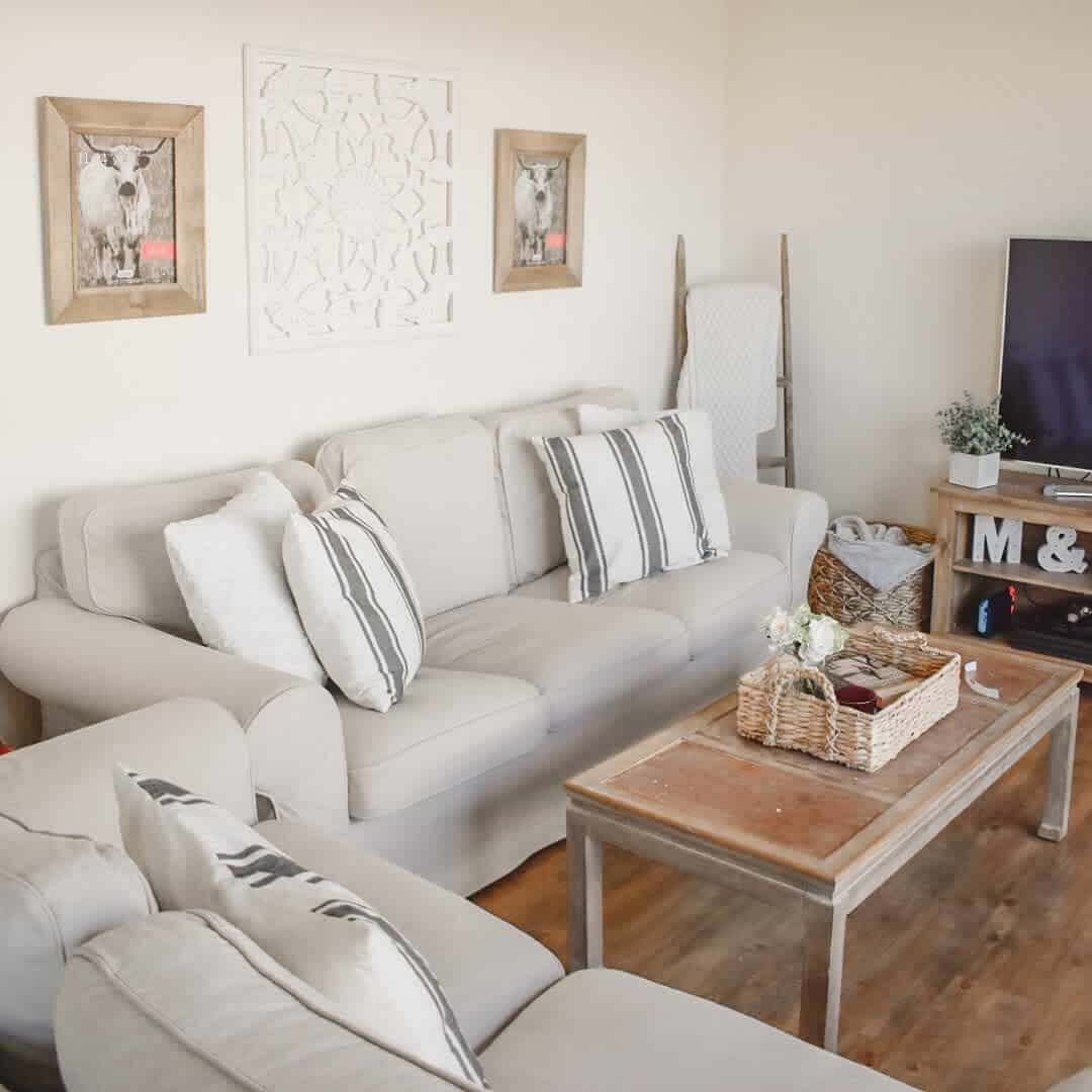 farmhouse living room gray couch cow wall art vintage table