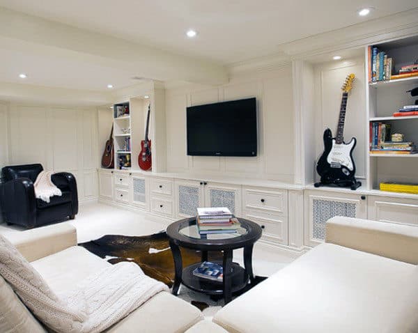 white basement room guitars on display black accent chair white sofa wall mounted tv