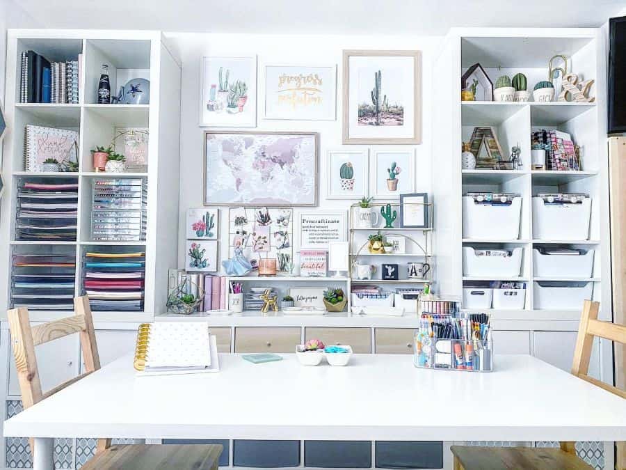 Bright and organized craft room with shelving, cactus-themed wall art, and a spacious table for creative projects