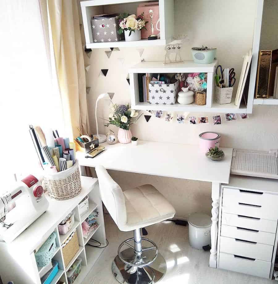 Charming and organized craft room with a white desk, storage cubes, and soft pastel decor for a cozy and productive space