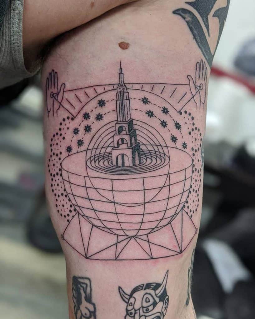 Thigh tattoo with an abstract geometric tower, spheres, and cosmic elements, creating a surreal, futuristic architectural design.