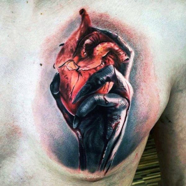 Realistic 3D tattoo of an anatomical heart being tightly gripped by a dark, shaded hand, creating a dramatic and intense chest design.