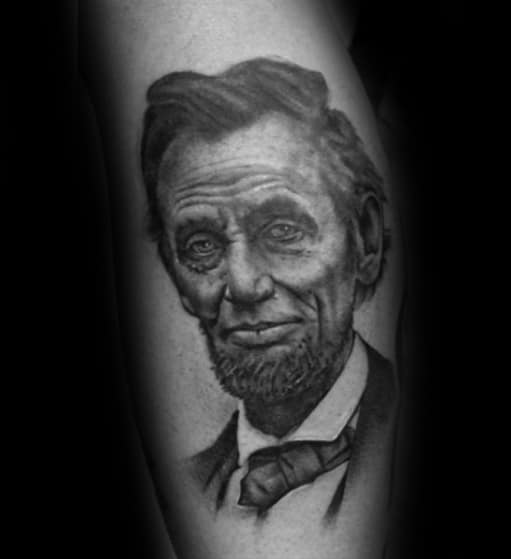 Tattoo of Abraham Lincoln's face with a beard and suit, in grayscale