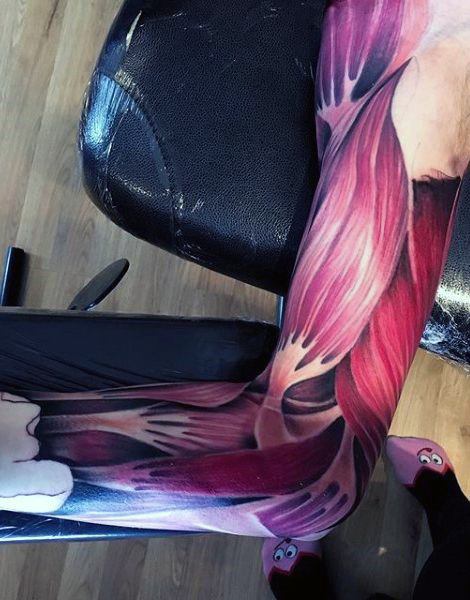 Realistic full-arm tattoo showing exposed muscle fibers in red and black, mimicking the look of peeled skin and anatomical detail.