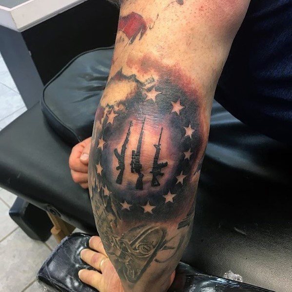 Patriotic tattoo featuring AR-15 rifles within a circle of stars, blending red, white, and blue shading, symbolizing American pride and gun rights.