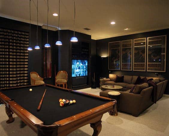 Cozy game room with a pool table, large TV, sofa seating, and warm lighting