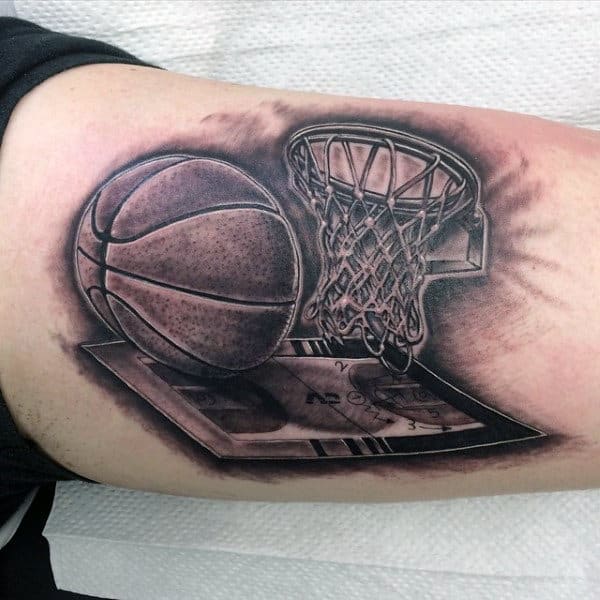A tattoo of a basketball, hoop, and play diagram on an arm