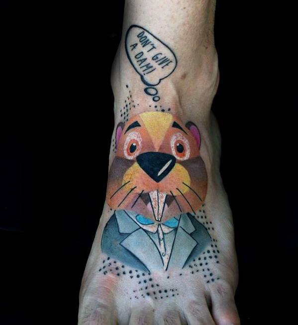 Colorful cartoon beaver tattoo on foot wearing a suit, with speech bubble saying “Don’t give a dam!” and dotted background accents.