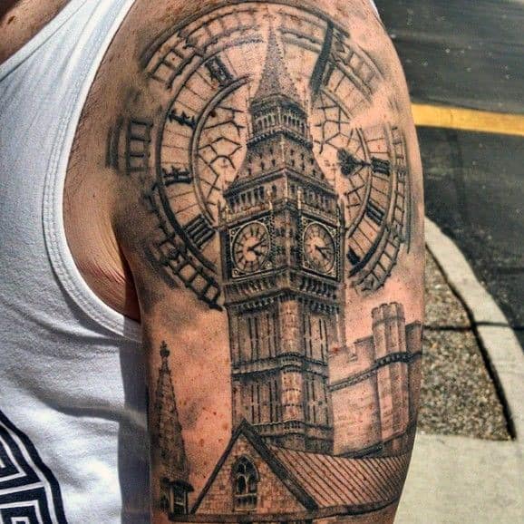 Detailed black and grey tattoo of Big Ben with the clock face and surrounding architecture, featuring intricate shading and texture on the upper arm.