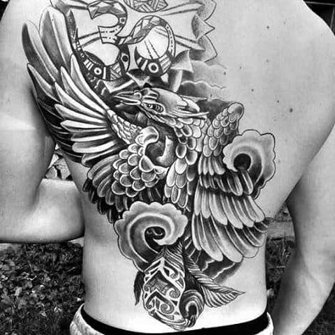 Full back tattoo in grayscale of a bird with outstretched wings and intricate patterns