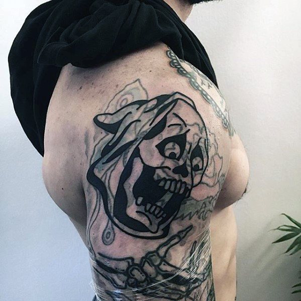 Person with a blast over screaming skull tattoo on their upper arm