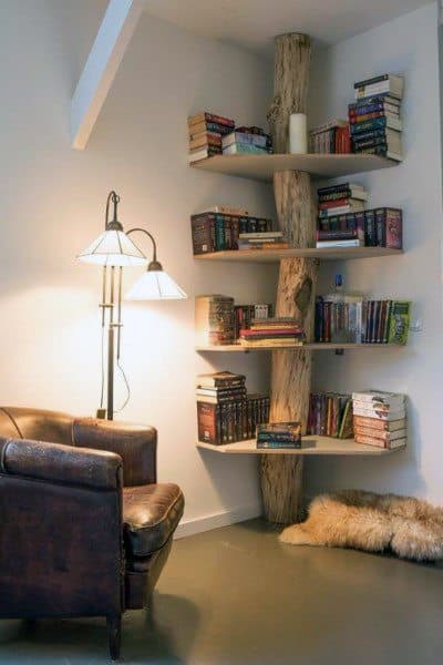 Cozy reading nook with a leather chair and corner bookshelves built around a wooden beam