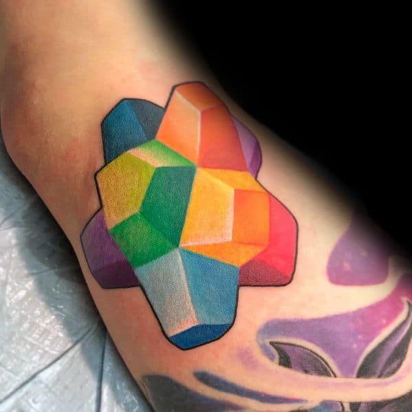 Vibrant tattoo of a colorful rock candy cluster with a geometric design, featuring bold shading and a striking 3D effect.