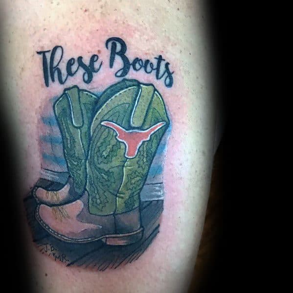 Tattoo of a pair of green cowboy boots with a Longhorn emblem and "These Boots" lettering, symbolizing Texan pride and Western heritage.