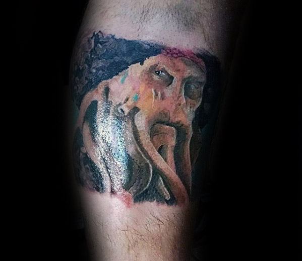 A detailed tattoo of Davy Jones, the mythical sea creature, adorns a person's arm