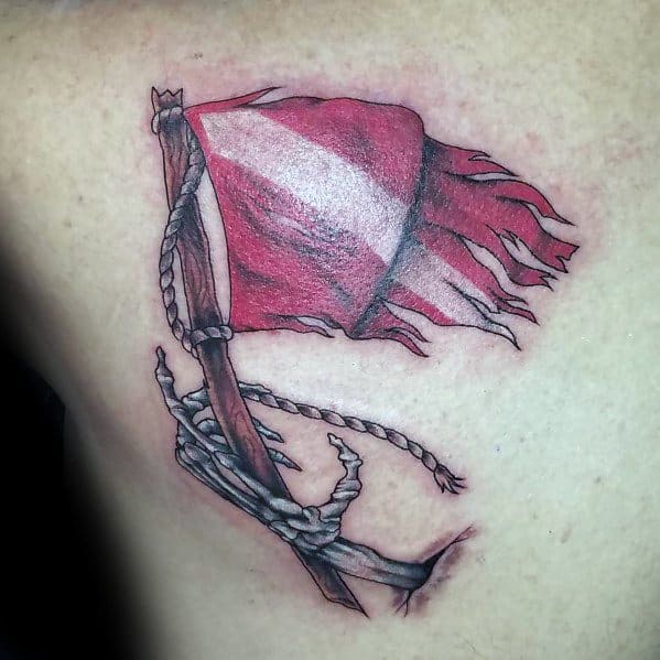 Tattoo of a tattered red and white dive flag on a wooden pole with a rope, symbolizing resilience, adventure, and a deep connection to diving.