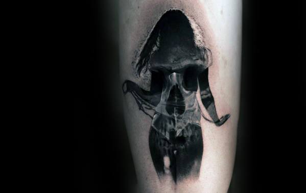 Black and grey double exposure tattoo of a woman’s silhouette revealing a skull within, blending sensuality and darkness.