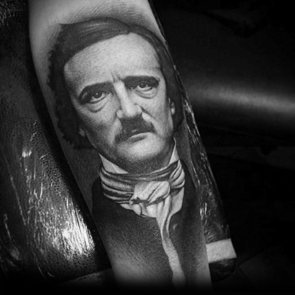 Hyper-realistic black and grey tattoo of Edgar Allan Poe with smooth shading, lifelike details, and a solemn facial expression.