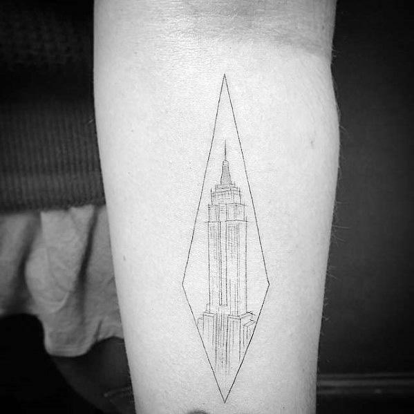 Minimalist Empire State Building tattoo framed inside a geometric diamond shape on a man's forearm.