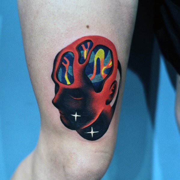 Surreal gradient tattoo of a head with colorful abstract brain shapes and glowing stars on the face, blending red, blue, and yellow tones.