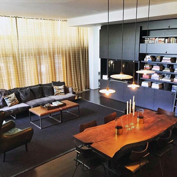 Open plan living and dining area with large sectional sofa, wood table, and modern lighting.