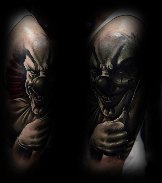 Black and grey tattoo of a sinister clown with a menacing grin, detailed shading, and eerie depth for a dark and haunting horror look.
