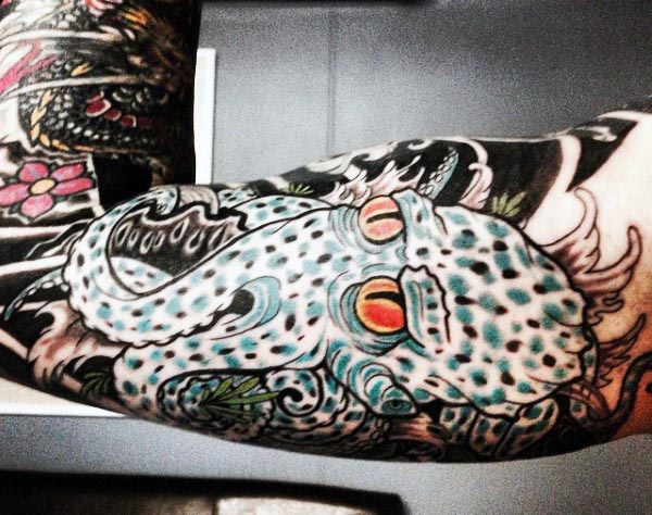 Colorful tattoo of a spotted octopus with intricate shading and vibrant red and yellow eyes, wrapping around the bicep in a bold design