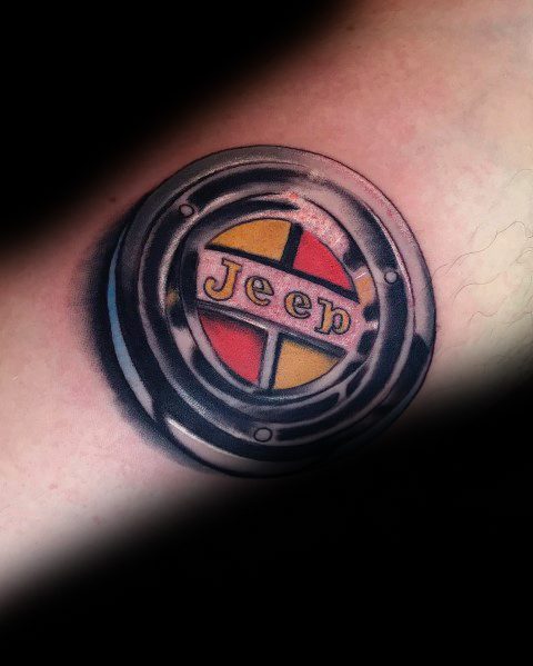Realistic Jeep tattoo featuring a detailed hubcap design with a metallic look, showcasing the Jeep logo and a red, yellow, and black color scheme.