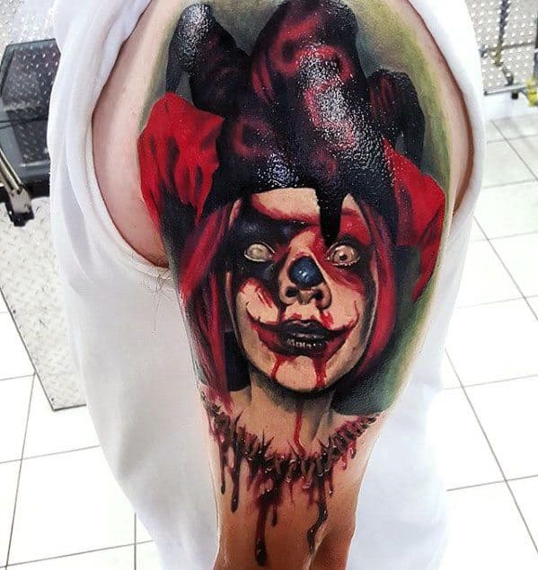 A colorful tattoo of a sinister jester clown with blood dripping from its face and neck, featuring bright eyes and a dramatic, eerie expression.